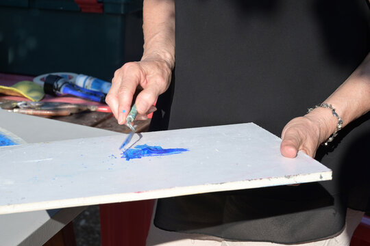 artista spalma i colori a tempera su di una tavolozza bianca