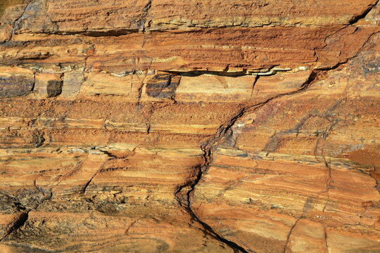 Faszinierende Sandsteinformation mit markanten Sedimentschichten und bunten Kieselsteinen. Hochwertige Detailaufnahme von geologischer Struktur und Erosion f&uuml;r Stockfotografie.