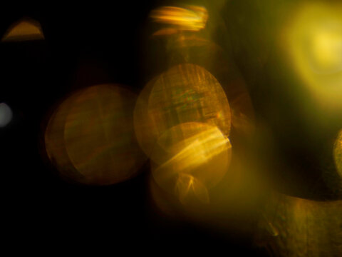 Warm orange light leaks on black. Abstract background for design and special effects. Random shapes and form. Lens flare.