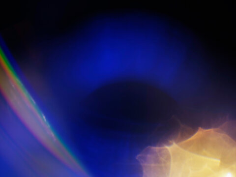 Warm orange and blue light leaks on black. Abstract background for design and special effects. Random shapes and form. Lens flare.