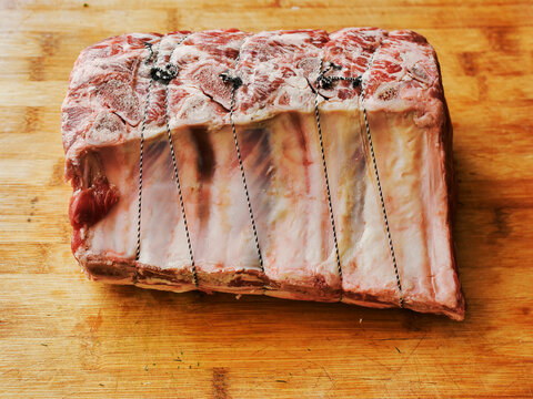 Huge carvery rib roast on the bone is on a wooden cutting board. Butcher craft and skill product. Top quality beef meat with high value and price tag due to premium cut and complicated production.