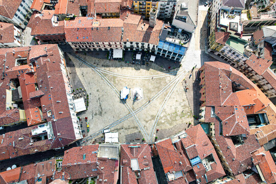 Aerial view of the historic Piazza Cavour surrounded by traditional red-tiled rooftops and urban architecture in Vercelli, Piedmont, Italy.