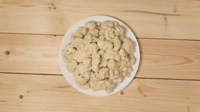Pickled cauliflower florets rotating on a plate