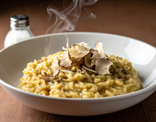 Naklejka premium White truffle oil mist is sprayed from a small glass atomizer over a bowl of creamy mushroom risotto with foam.