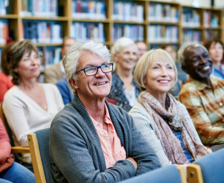 Group of happy senior older mature people friends men and women sitting audience row chairs classroom library community center watching presentation lecture cinema smiling listening together concept