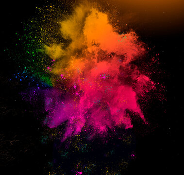 Colorful rainbow holi paint powder explosion isolated on black background