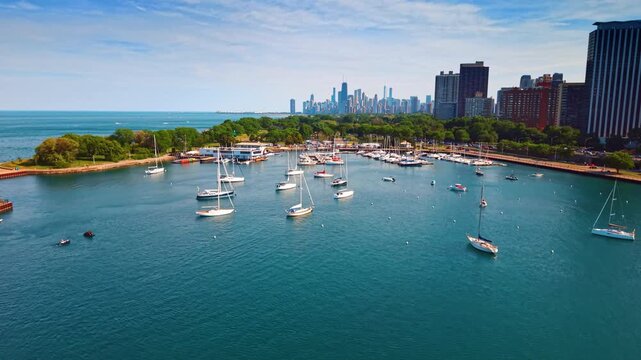 Rising over blue marina with boats at the berths and on the water. Footage over Chicago Harbor at daytime.