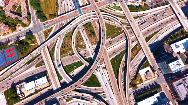 Many cars on the swirling, circular pattern of sweeping concrete flyover ramps and loop bridges. The Jane Byrne Interchange in modern Chicago, Illinois, USA at daytime.