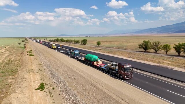 Industrial Transport Convoy Moving Oversized Load on Divided Highway