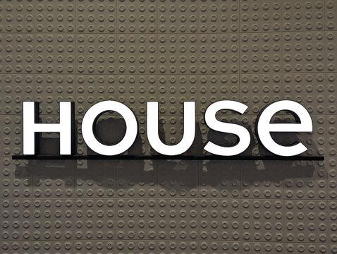 Warsaw, Poland,May 03, 2026. Close up view of a modern white metallic House clothing retail brand sign attached to a textured beige brick wall surface. High quality photograph.