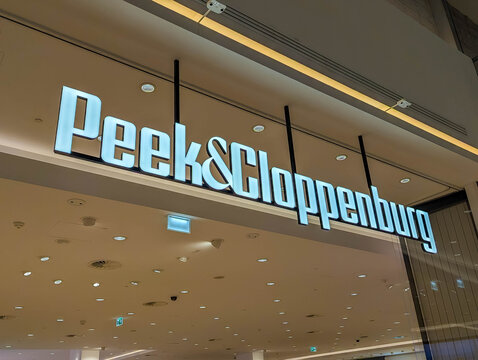 Warsaw, Poland,May 03, 2026. Wide angle view of the glowing corporate white signboard of Peek and Cloppenburg fashion department apparel store. High quality photograph.