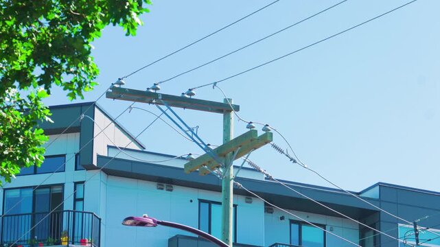 Wooden utility pole with overhead power lines in residential neighborhood