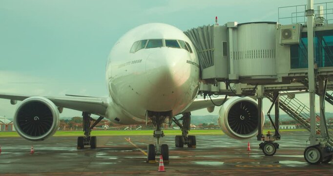 Modern passenger airplane Boeing docked at airport terminal with jet bridge