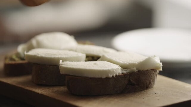 Slow motion man making bruschetta with pesto and mozzarella
