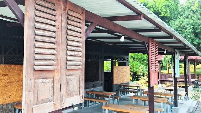 Wide view of traditional wooden louvered window shutter on rustic outdoor cafe terrace