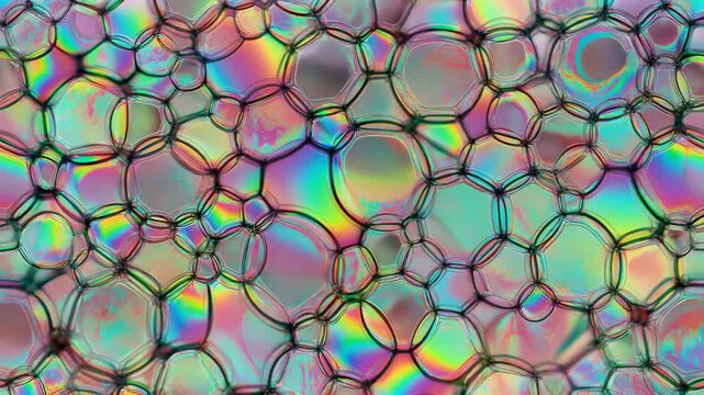 Iridescent soap bubbles, tightly packed hexagonal pattern with vibrant rainbow colors and shimmering reflections, seamless loop, cinematic macro footage, symbolizing connectivity, innovation