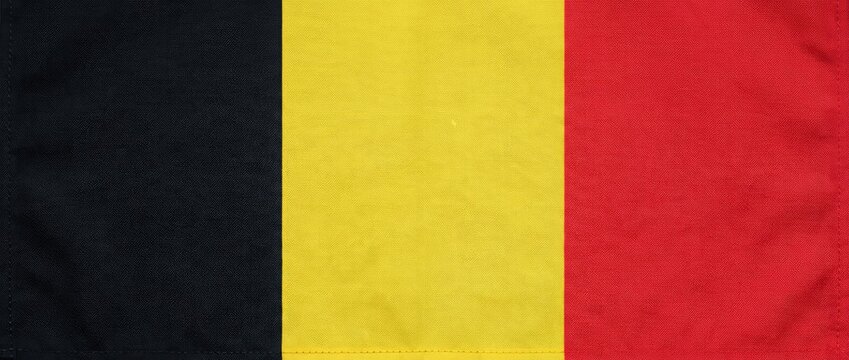 A close-up shot of the Belgian flag with its vertical stripes of black, yellow, and red
