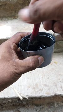 Cleaning paintbrush by stirring it in solvent thinner container