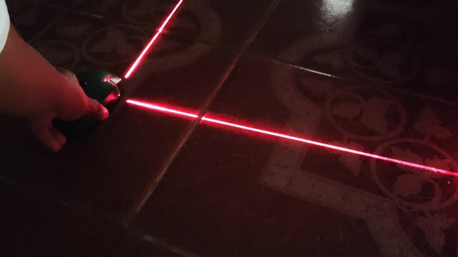 Placing and adjusting self leveling laser level tool on the floor