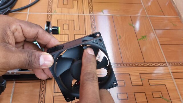 Manually spinning 24v cooling fan with broken blade inspection