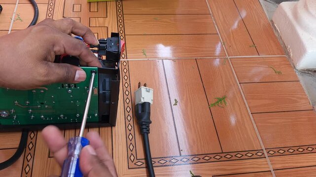 Using screwdriver to remove cross head screw from electronic circuit board
