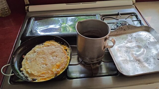 Traditional rural breakfast cooking egg omelet next to rustic coffee pot
