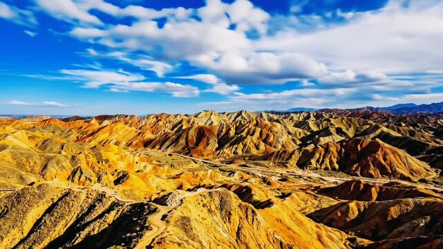 Stunning panoramic view of the colorful Danxia landform mountains under a bright blue sky.