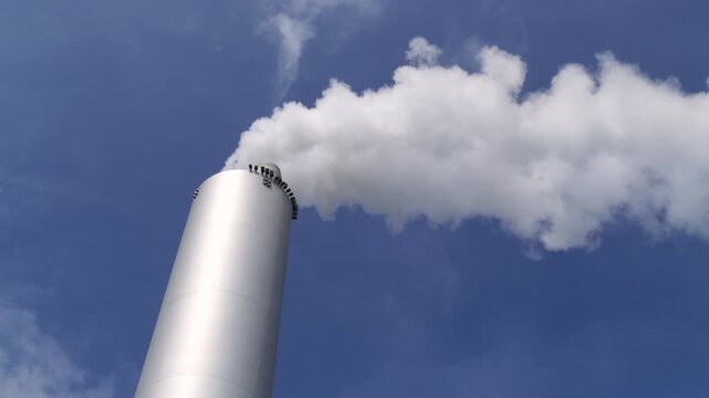A Sleek Industrial Smokestack Churning White Plumes into Blue Skies
