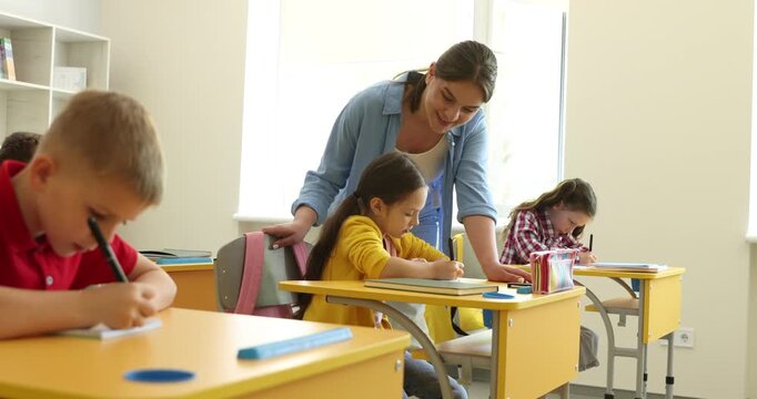 Teacher helping student during lesson in classroom