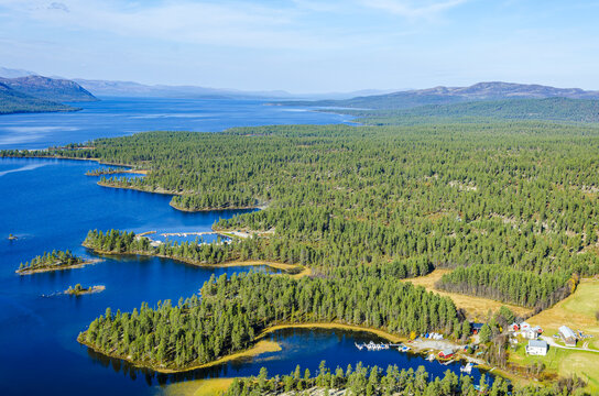 Aerial view of Femund lake surrounded by dense pine forests and mountainous terrain in Norway.