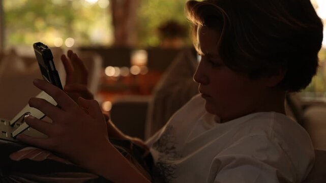close up profile of pre teen boy looking at tablet at home