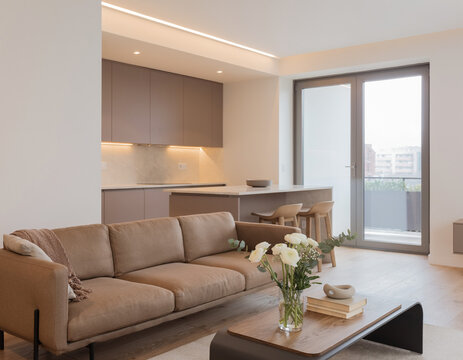 A close-up of a very modern living room featuring simple, concealed modern lighting and floral accents; the new furniture avoids a futuristic look, complementing the open-plan layout shared with the k