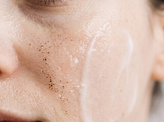 Fototapeta premium Applying facial scrub on skin for a natural skincare routine close up