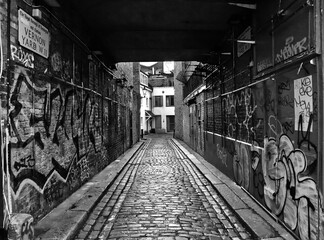 Fototapeta premium Black and white view of an urban pedestrian underpass with walls covered in graffiti, London