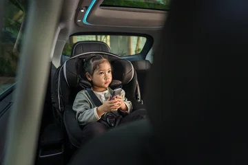 preschool child girl watching rear entertainment screen or ceiling screen while sitting in car seat, safety baby chair travelling © geargodz