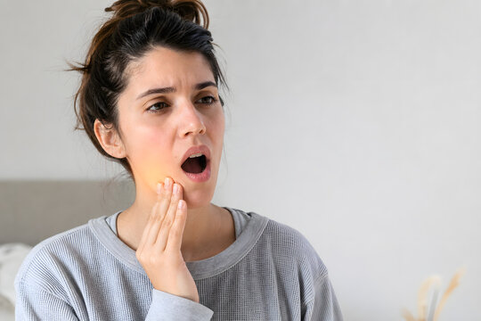 Woman waking with painful stiff jaw at home