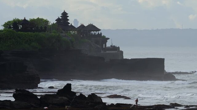 Misty Coastline Tanah Lot Temple Silhouette Soft Morning Light, Gentle Waves Lapping Rocky Shore, Distant Shrine On Cliff, Calm Meditative Atmosphere, Pilgrim Path And Green Foliage, Bali island