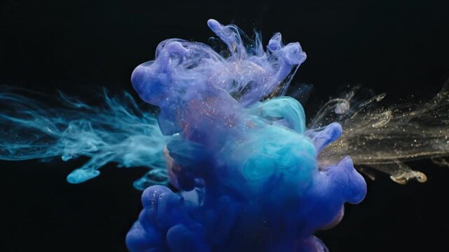 Abstract blue and cyan ink cloud swirls with gold dust particles suspended in water against a black background creating dynamic artistic fluid shapes