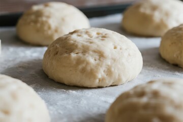 Fototapeta premium Unbaked dough rolls on a floured baking sheet, ready for baking
