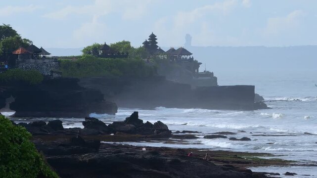 Silent Coastal Temple. Misty Shoreline With Ancient Shrine. Eroded Rocks Leading To Tranquil Sacred Site. Serene Landscape Featuring Weathered Stones And Distant Spiritual Monument, Tanah Lot temple