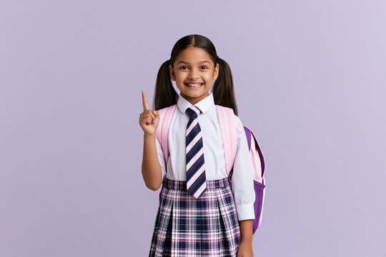 Schoolgirl student smiling and pointing up wearing a uniform with a backpack child