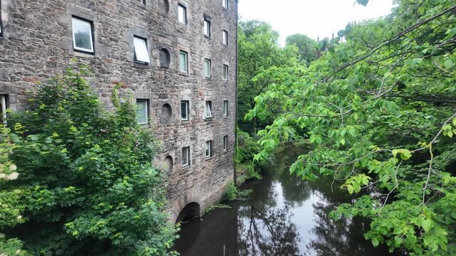 Historic stone building at Dean Village, Edinburgh. A multi-story masonry structure stands beside the scenic Water of Leith river.