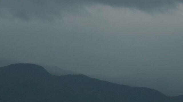 Silhouette of distant mountain ranges and gray clouds