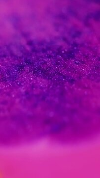 Vertical video. Shimmer art. Bokeh light. Defocused pink purple orange color paint in water marble sparkling liquid floating on abstract background.