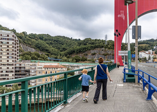 Woman and Child Walking Across Bridge