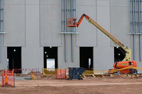 Data center building under construction with a boom lift at the exterior wall, illustrating commercial development, AI infrastructure, building installation, and engineering
