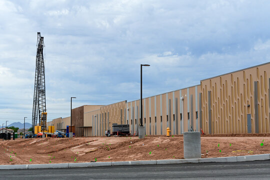Hyperscale data center under construction with prefabricated exterior wall panels and heavy equipment, representing digital infrastructure expansion, cloud computing, and technology industry growth