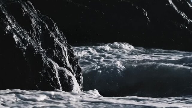 Powerful ocean wave crashing against dark rocks creating white sea spray, dynamic water splash, energetic nature
