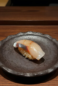 Exclusive chef&rsquo;s signature sushi course featuring lightly aged fish prepared using traditional edomae techniques, artisan ceramic plate, intimate luxury omakase experience.
