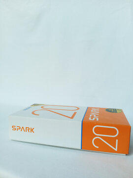 Tecno smartphone paper box package lying down flat on white background. Side view of Spark 20 phone. An android phone with fingerprint, proximity sensor, dual flash. Kumasi, Ghana - December 9, 2025